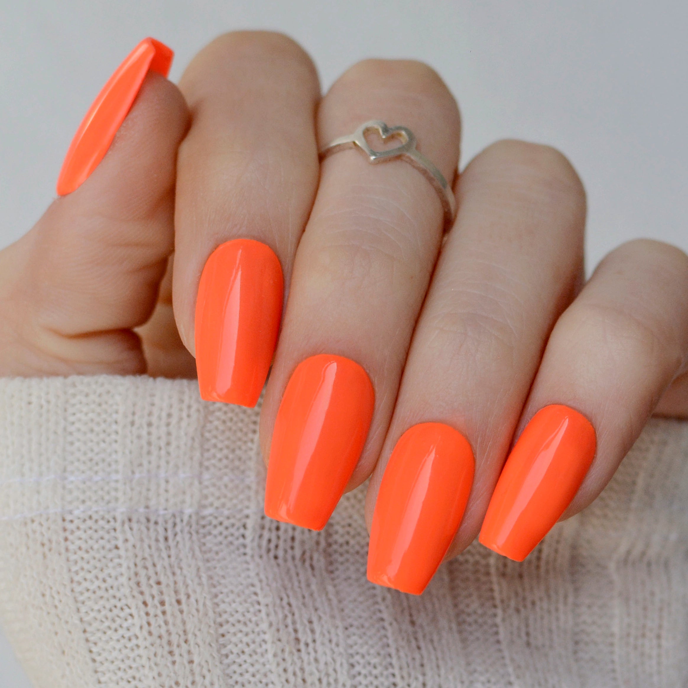 Gel de color tangerina de 7ml de Mi Tienda, envase con gel vibrante para uñas en una mano con esmalte.